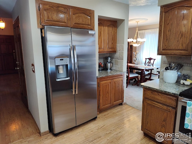 kitchen featuring tasteful backsplash, brown cabinetry, and stainless steel fridge with ice dispenser