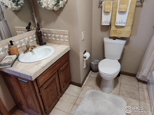 bathroom with toilet, vanity, decorative backsplash, and tile patterned floors