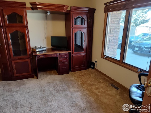 office space with light carpet, visible vents, and baseboards