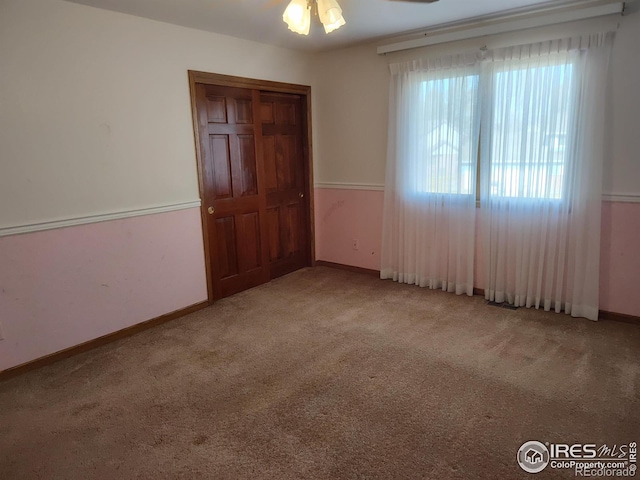 unfurnished bedroom featuring a closet, carpet flooring, and baseboards