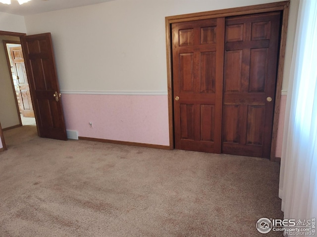 unfurnished bedroom with carpet flooring and baseboards