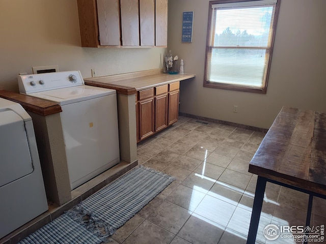 washroom featuring washer hookup, light tile patterned flooring, cabinet space, and baseboards