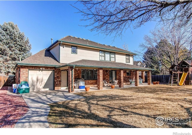 view of front facade featuring brick siding, a front yard, fence, a garage, and driveway