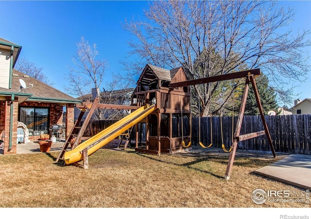 view of playground featuring a lawn, a patio area, and fence