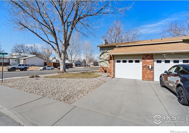 view of yard featuring an attached garage and concrete driveway