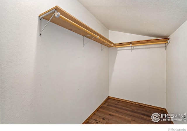 spacious closet with vaulted ceiling and wood finished floors