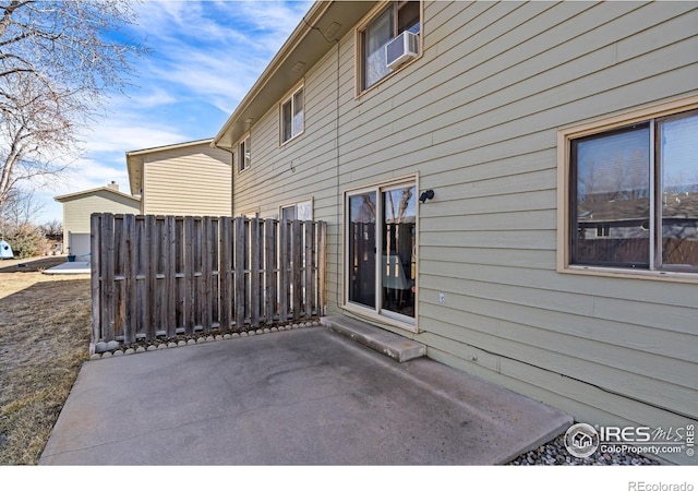 view of side of home featuring cooling unit, fence, and a patio