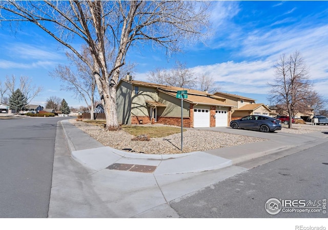 view of front of home with an attached garage, a residential view, and concrete driveway