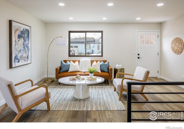 living area with recessed lighting, baseboards, and wood finished floors