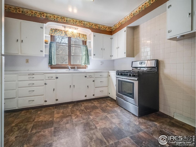 kitchen featuring light countertops, gas stove, white cabinetry, and tile walls