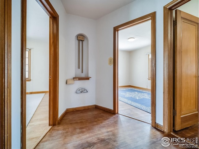 hallway with baseboards and wood finished floors