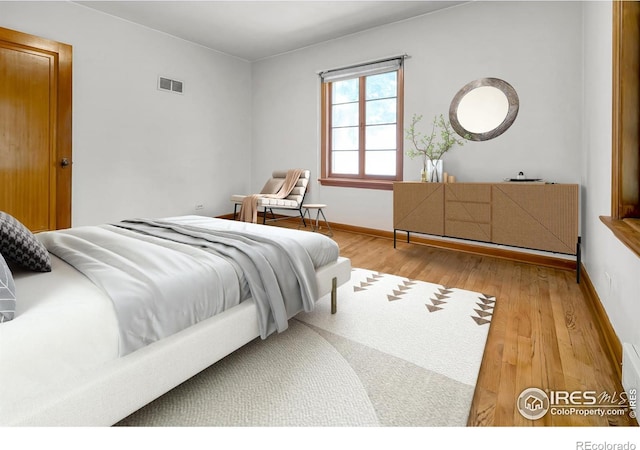 bedroom with baseboards, visible vents, and wood finished floors