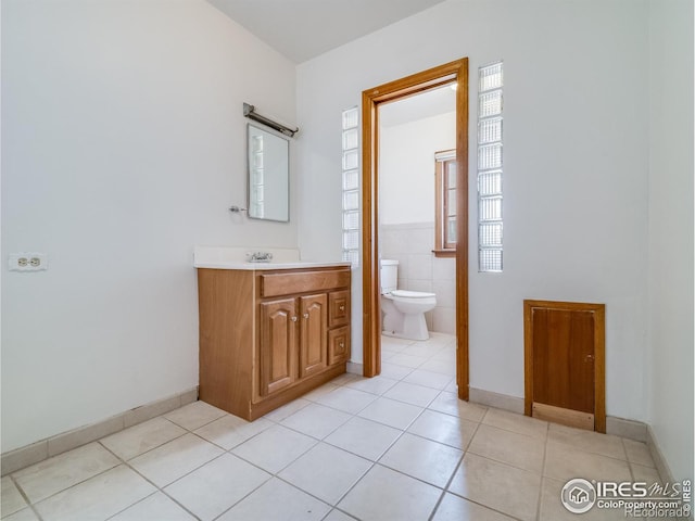 bathroom featuring toilet, vanity, baseboards, and tile patterned floors