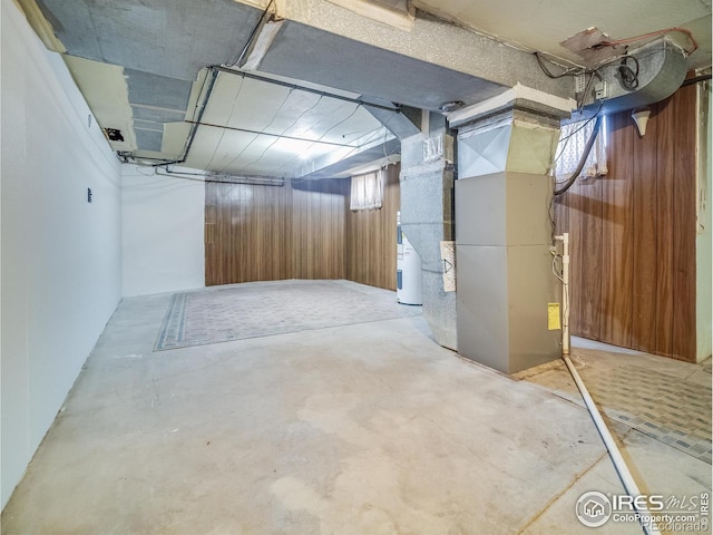 unfinished basement with water heater and heating unit