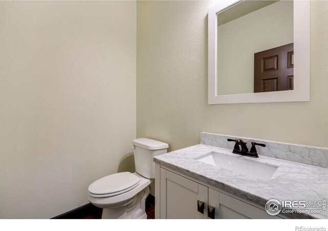 half bathroom featuring toilet and vanity