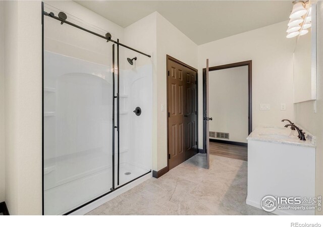 full bathroom with vanity, baseboards, visible vents, and a stall shower