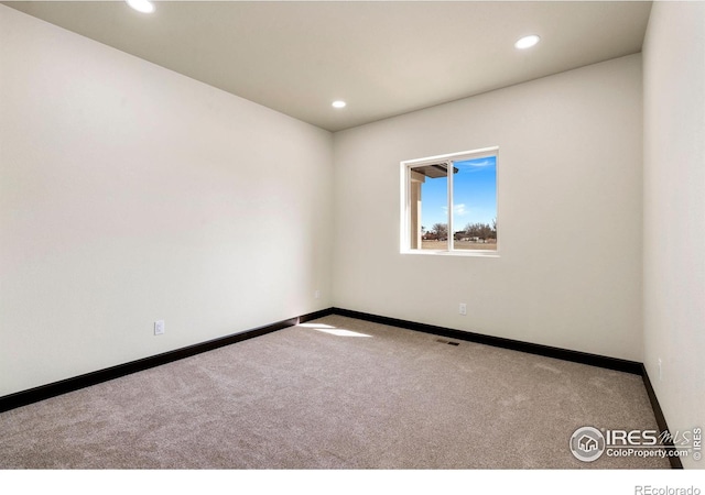 spare room with recessed lighting, baseboards, carpet floors, and visible vents