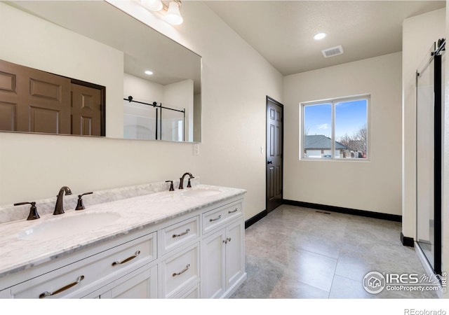 full bathroom with a shower with door, visible vents, double vanity, and a sink