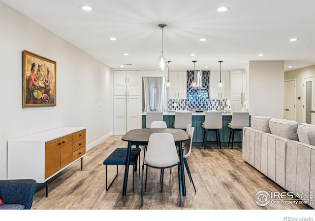 dining space with baseboards, recessed lighting, and light wood-style floors