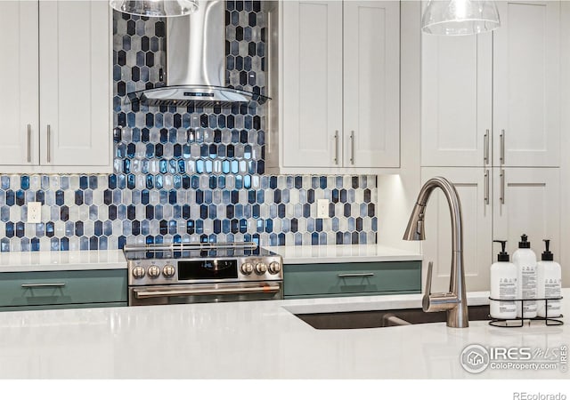 kitchen with green cabinets, light countertops, stainless steel electric range oven, wall chimney exhaust hood, and tasteful backsplash