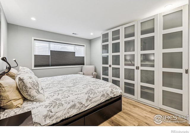 bedroom with light wood-type flooring, visible vents, and recessed lighting