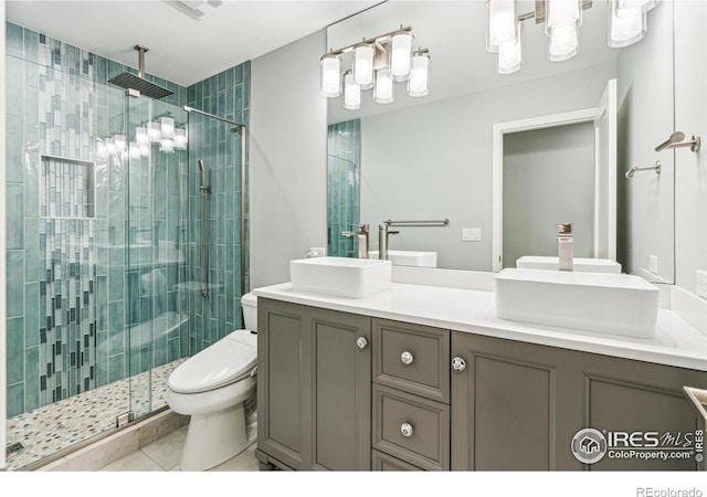 full bathroom with a sink, a shower stall, toilet, and double vanity