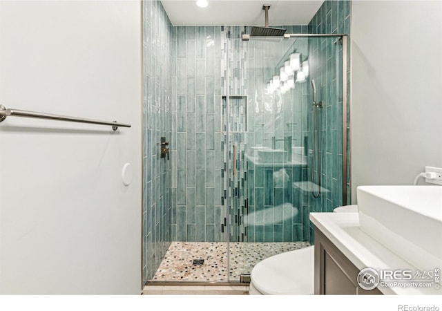 bathroom with vanity, a shower stall, and toilet