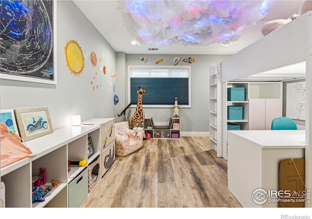 playroom with wood finished floors, visible vents, and baseboards