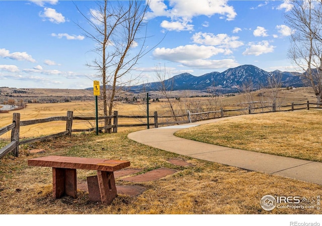 view of yard featuring fence, a mountain view, and a rural view