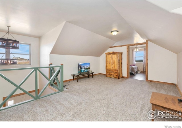 bonus room featuring vaulted ceiling, a notable chandelier, carpet flooring, and baseboards