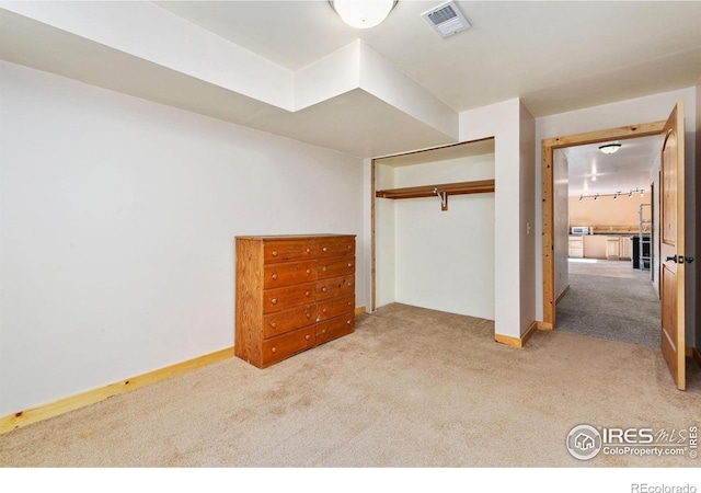 unfurnished bedroom with baseboards, a closet, visible vents, and carpet flooring