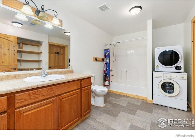 bathroom featuring stacked washer and clothes dryer, visible vents, shower / bathtub combination with curtain, toilet, and vanity