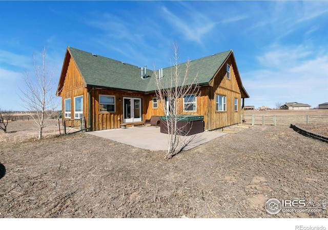 back of property with french doors, a patio area, fence, and a shingled roof