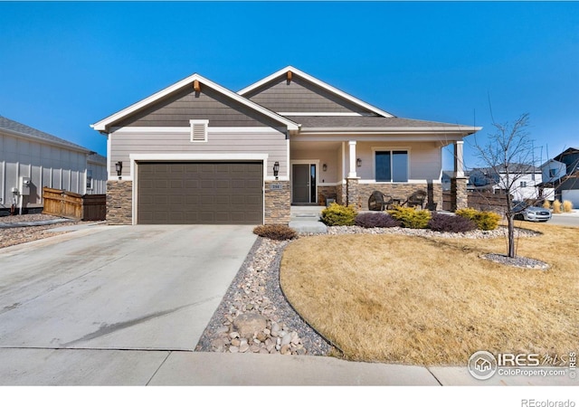 craftsman-style house with a garage, concrete driveway, and stone siding