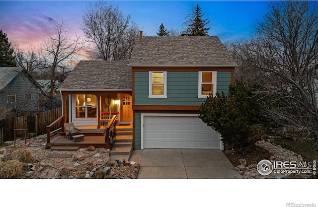 view of front of property featuring fence, covered porch, a shingled roof, concrete driveway, and a garage