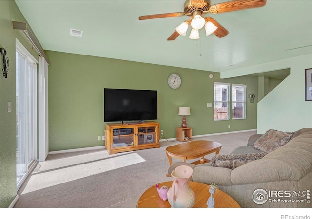 living area featuring ceiling fan, carpet flooring, visible vents, and baseboards