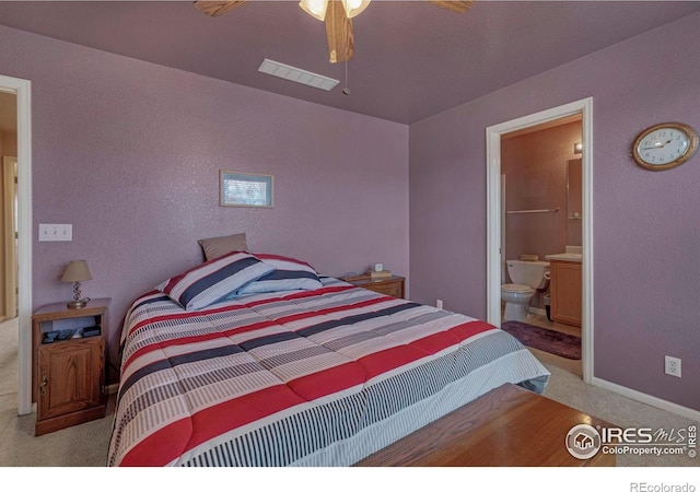 carpeted bedroom featuring visible vents, connected bathroom, and baseboards