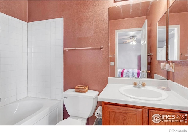 ensuite bathroom with a textured wall, toilet, a ceiling fan, vanity, and ensuite bath