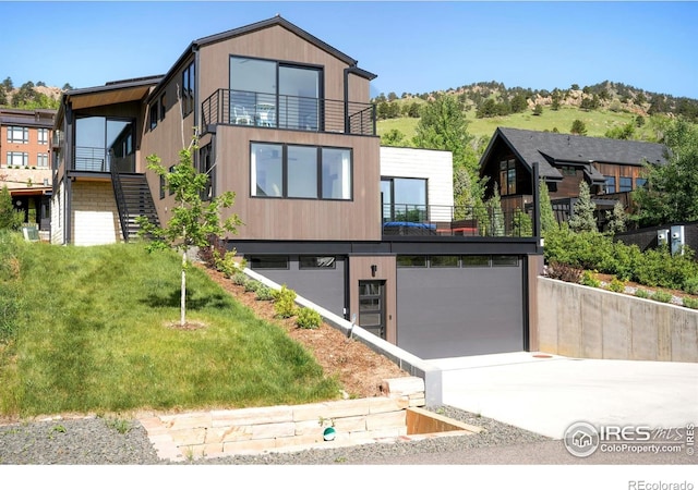 2586 3rd St, Boulder, CO 80304 - contemporary house with a balcony, an attached garage, driveway, a front lawn, and stairway