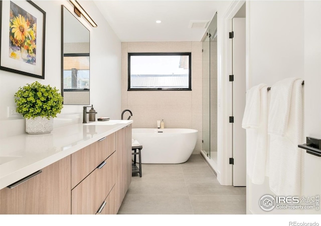 2586 3rd St, Boulder, CO 80304 - full bathroom with vanity, tile walls, a freestanding bath, a shower stall, and tile patterned flooring