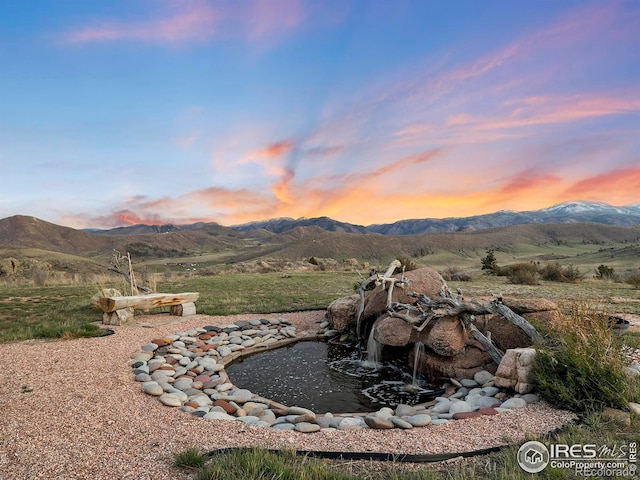 view of mountain feature with a small pond