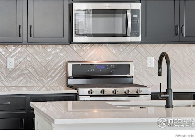 kitchen featuring appliances with stainless steel finishes, light stone countertops, and decorative backsplash