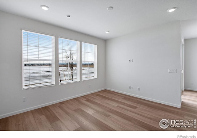 spare room featuring baseboards, recessed lighting, and light wood-style floors