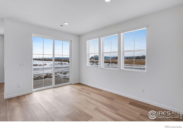 empty room featuring light wood-style flooring, baseboards, and recessed lighting