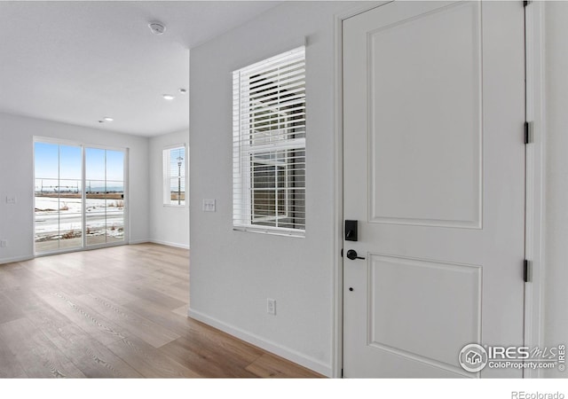 entryway featuring recessed lighting, wood finished floors, and baseboards