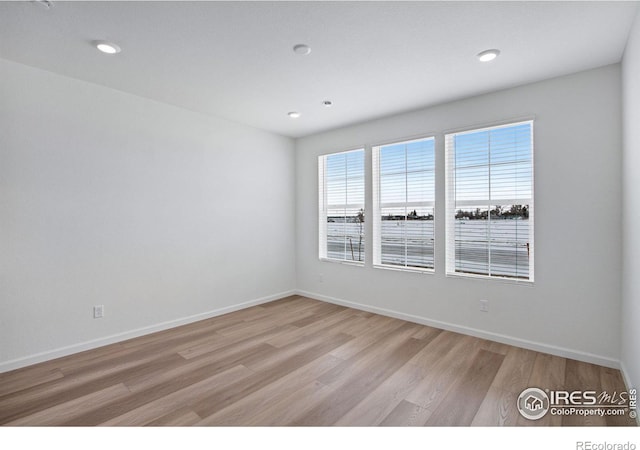 unfurnished room featuring recessed lighting, baseboards, and light wood finished floors