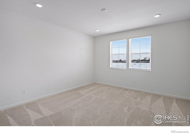 unfurnished room with recessed lighting, baseboards, and light colored carpet