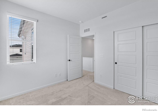 unfurnished bedroom featuring a closet, visible vents, baseboards, and carpet flooring