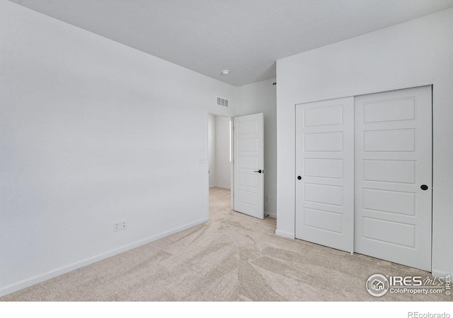 unfurnished bedroom featuring carpet floors, a closet, visible vents, and baseboards