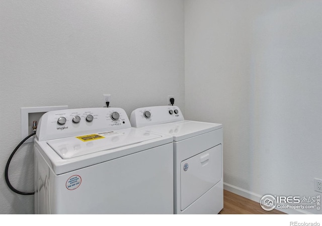 laundry room with laundry area, light wood-style flooring, baseboards, and washer and dryer